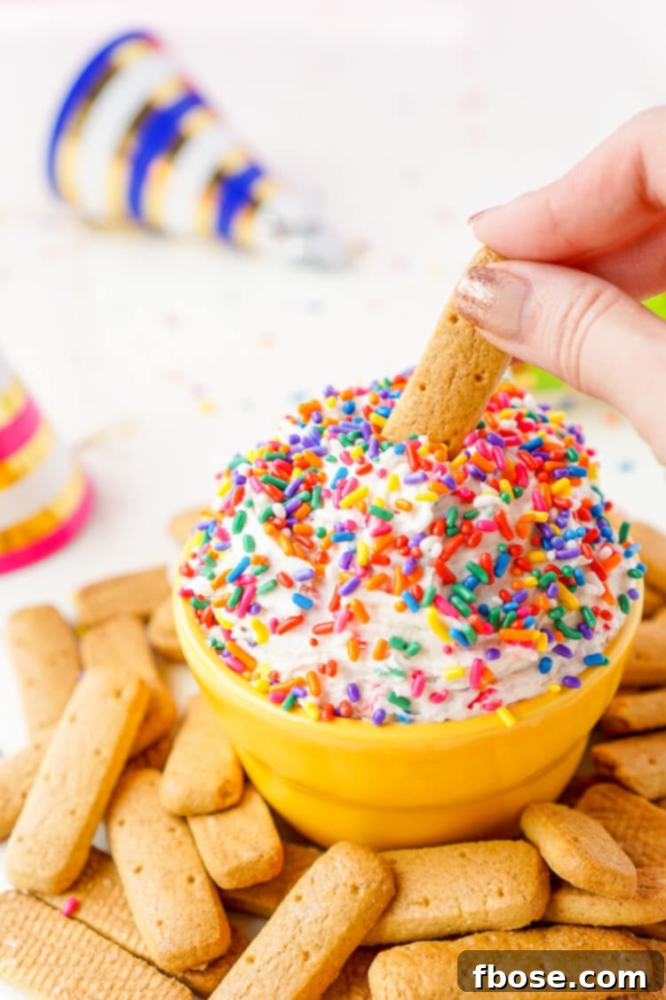 Delicious Funfetti Birthday Cake Dip served in a small bowl, garnished with extra sprinkles and a dipper.