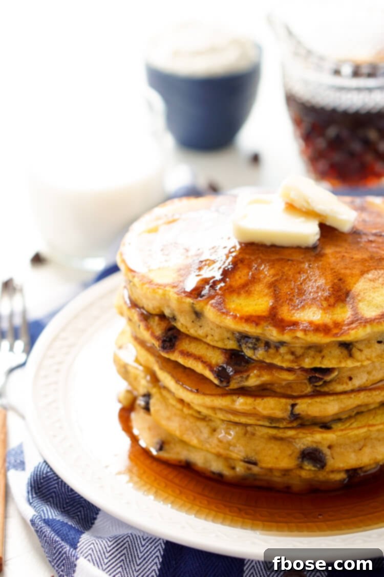 Close-up of golden-brown Pumpkin Chocolate Chip Pancakes with visible chocolate chips, ready to be served.