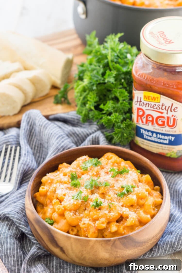 Creamy Marinara Mac and Cheese in a white bowl, garnished with fresh herbs.