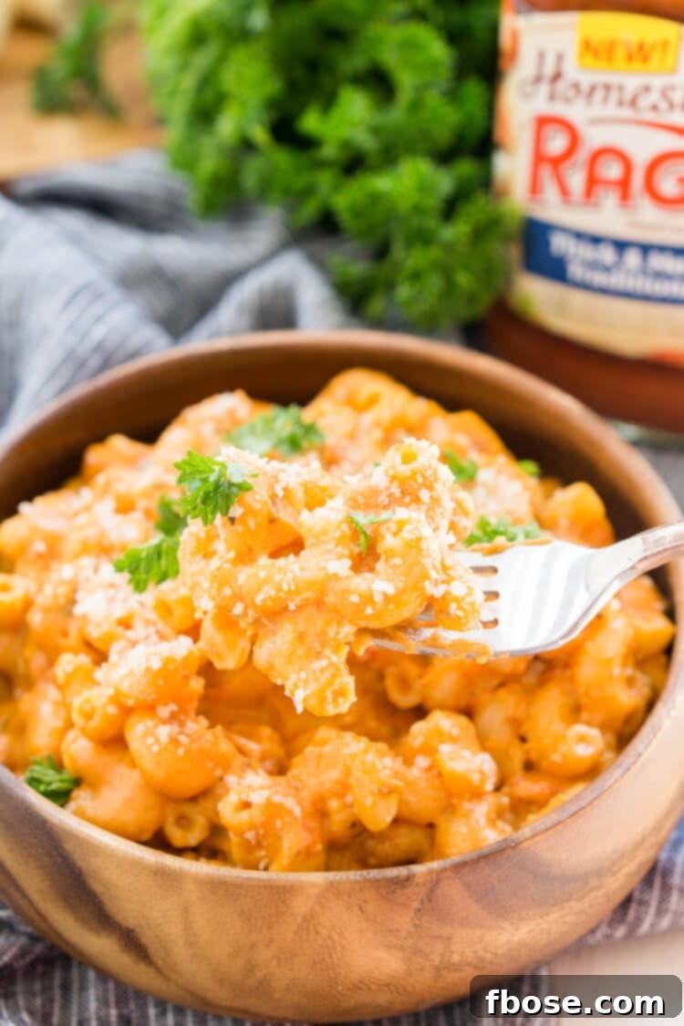 Ingredients for Marinara Mac and Cheese laid out on a wooden board: pasta, cheese, butter, milk, and Ragú sauce.