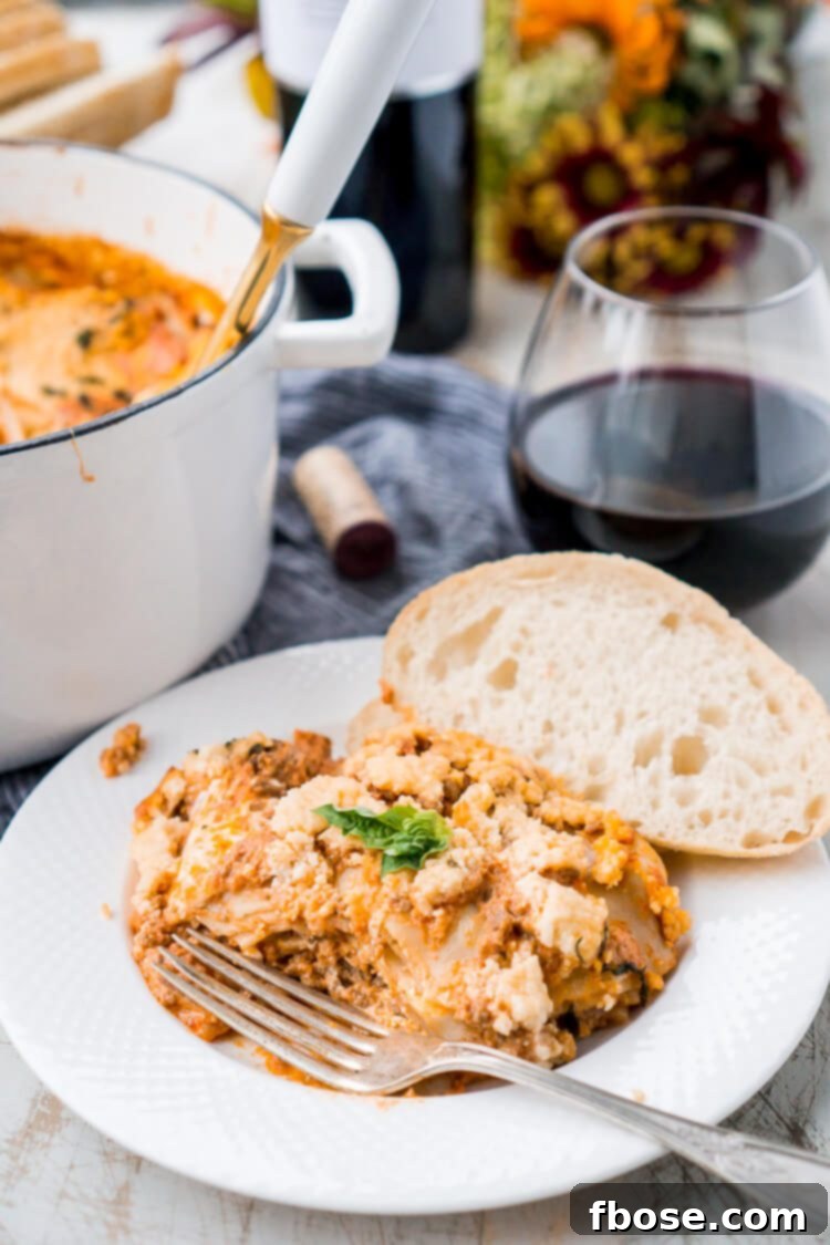 Easy One Pot Lasagna served directly from a red Dutch oven, showcasing its rustic charm and inviting texture with cheese pulls and herbaceous garnish.