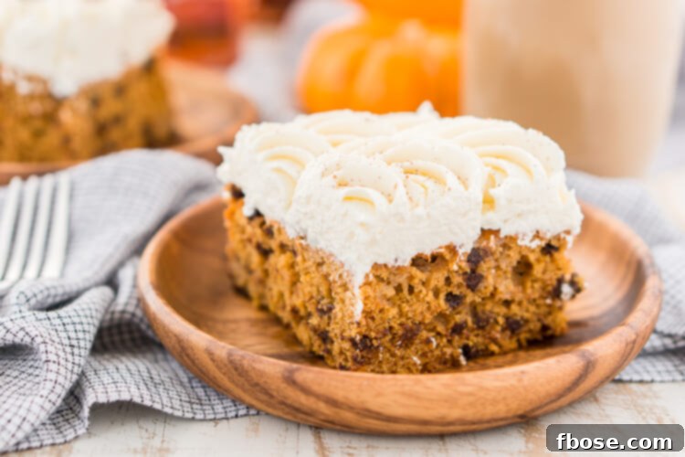 A slice of Pumpkin Chocolate Chip Poke Cake with frosting and cinnamon dusting