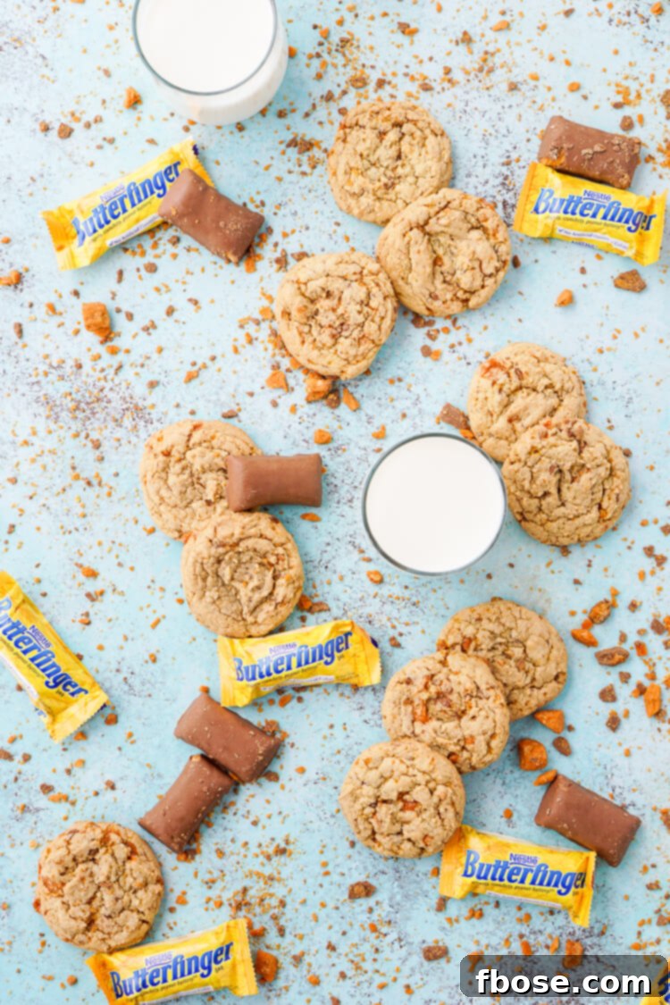 Decadent Butterfinger Pudding Cookies 3 Close-up shot of a single Butterfinger pudding cookie with visible candy bar pieces, sitting on a white background.