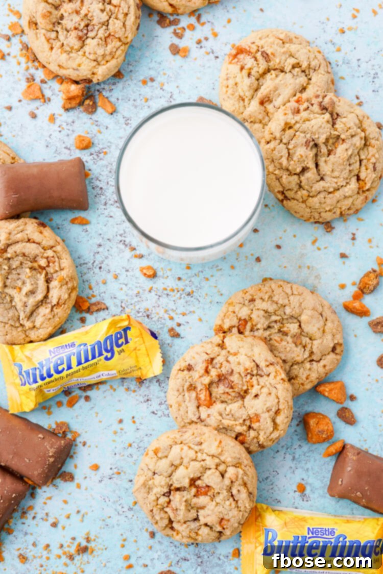Decadent Butterfinger Pudding Cookies 5 Freshly baked Butterfinger pudding cookies cooling on a wire rack, with some still on the baking sheet.