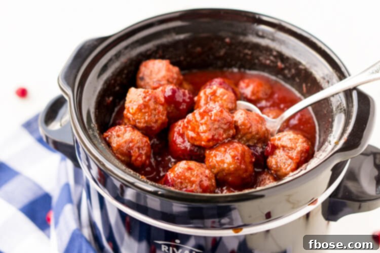 Three Cranberry Orange Meatballs on a small plate, ready to be served. A perfect party snack with a festive touch.