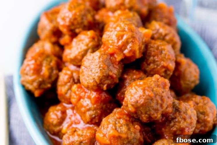 Close-up of Pineapple Tequila Meatballs simmering in a crockpot, showcasing the rich, glossy sauce.
