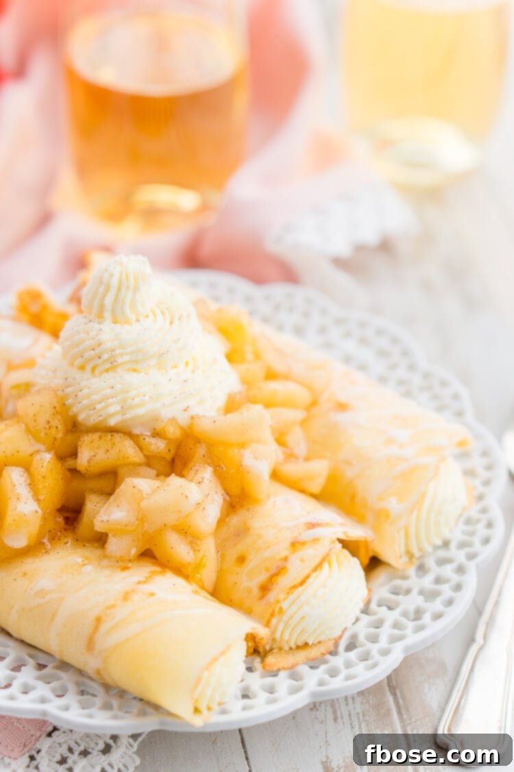 Fluffy Apple Cheesecake Crepes with fresh apples and whipped cream drizzle