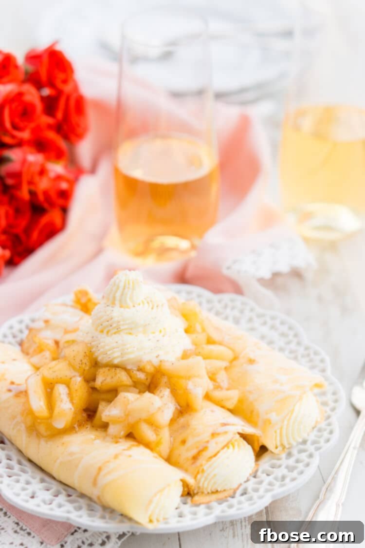 Overhead view of a prepared Apple Cheesecake Crepe, drizzled with sweet icing and surrounded by fresh apple slices