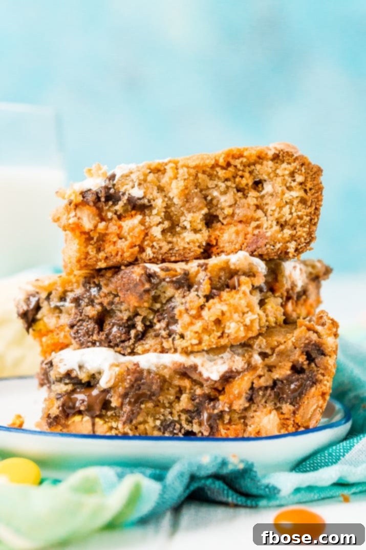 Peanut Butter Cloud Blondies 2 Deliciously sweet and chewy Peanut Butter Fluff Blondies loaded with chocolate chips and Reese's Pieces, featuring a delightful marshmallow swirl.