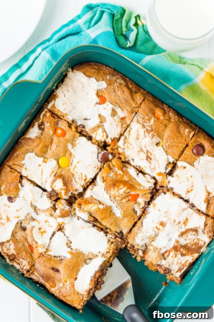 Peanut Butter Cloud Blondies 3 Close-up shot of Peanut Butter Fluff Blondies, showcasing the chewy texture and generous inclusions of chocolate chips and Reese's Pieces.