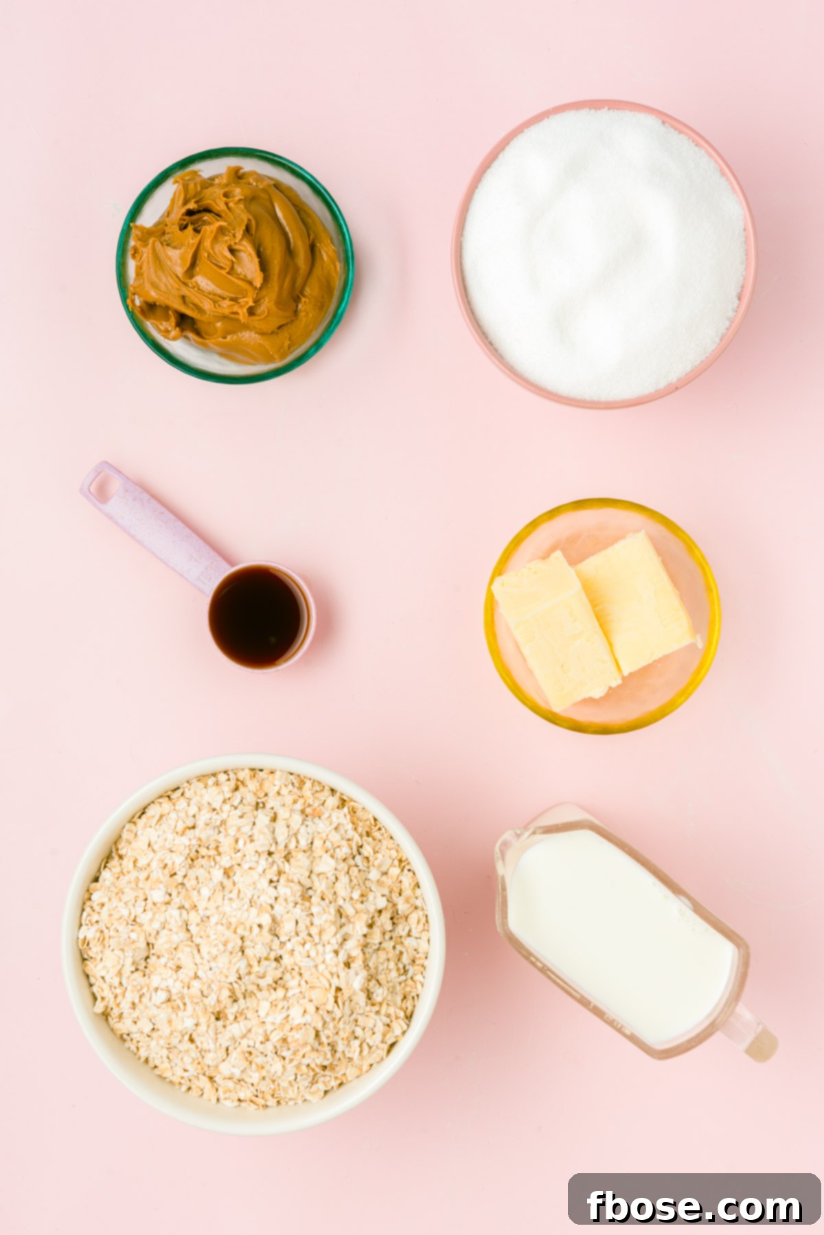 An overhead view of all the fresh ingredients laid out on a pink surface, ready for making cookie butter no bake cookies.