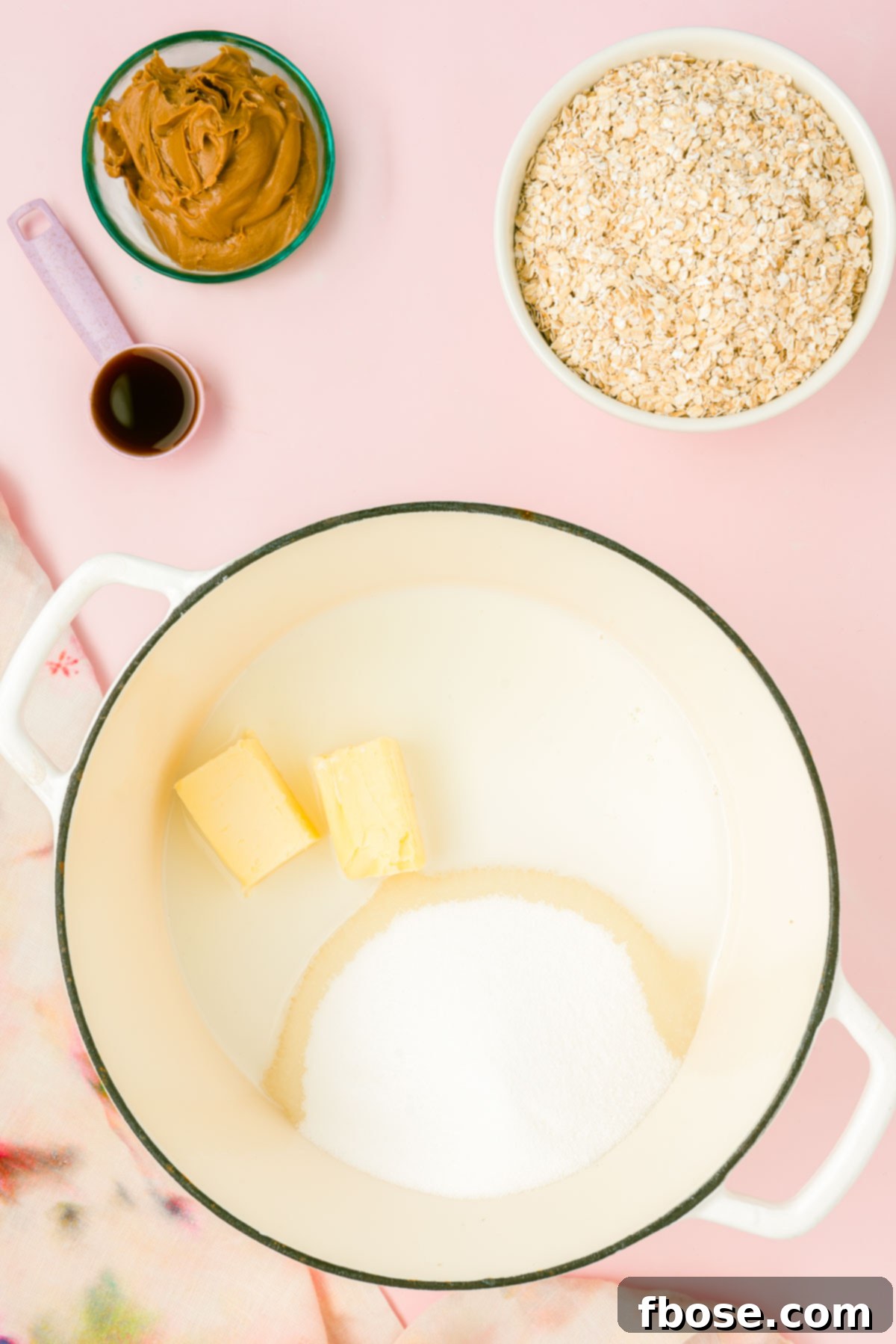 Butter, sugar, and milk are gently melting together in a Dutch oven pot, creating a smooth base for the cookies.