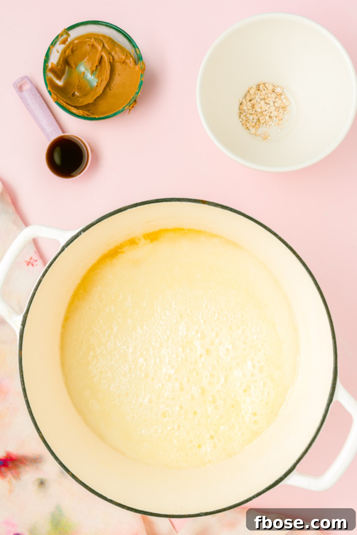 The butter, sugar, and milk mixture reaches a rolling boil in the pot, indicating it's ready for the next step.