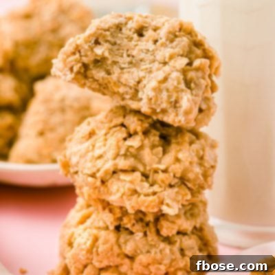 Three cookie butter no bake cookies stacked next to a bottle of milk.