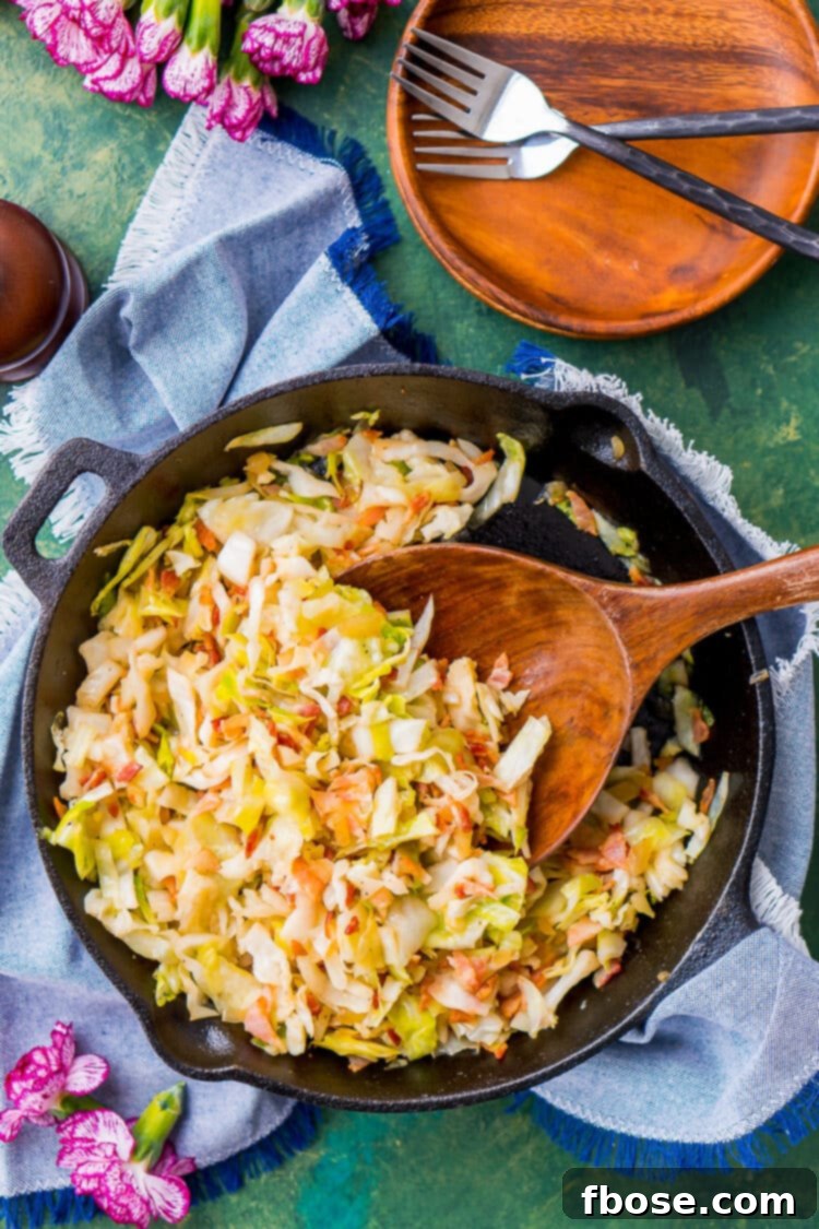 Overhead photo of fried cabbage and bacon in a cast iron skillet.