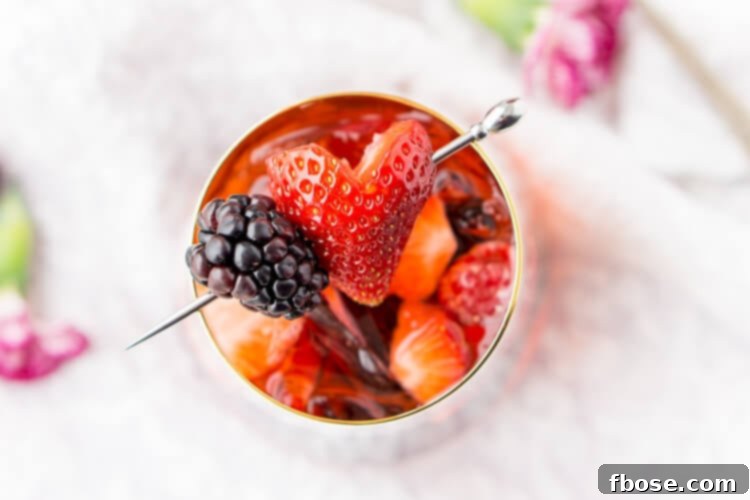 Rosé Berry Sangria is the perfect batch cocktail for Valentine's Day, Bridal Showers, and more! Made with rosé wine, Chambord, blackberry brandy, lemon-lime soda, and fresh berries!