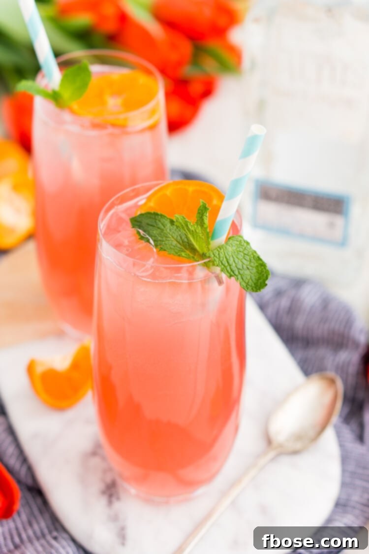A refreshing Cactus Cooler Tequila Cocktail garnished with a tangerine slice and fresh mint.