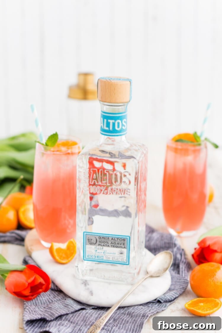 Close-up of a Cactus Cooler Tequila Cocktail with ice, citrus slices, and mint.