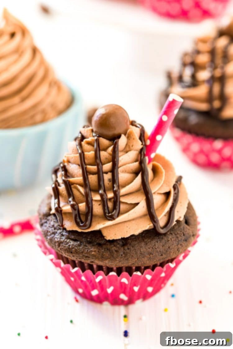 Chocolate cupcake topped with chocolate drizzle and whopper candy.