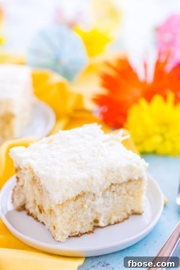 A beautifully frosted Coconut Poke Cake with shredded coconut topping, ready to be served at a spring or summer party.