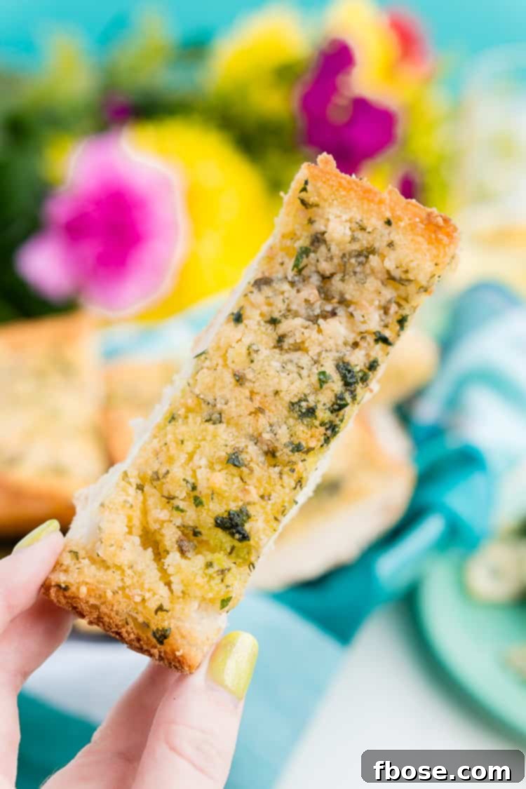 Close-up of golden Parmesan garlic bread on a baking sheet, fresh out of the oven.