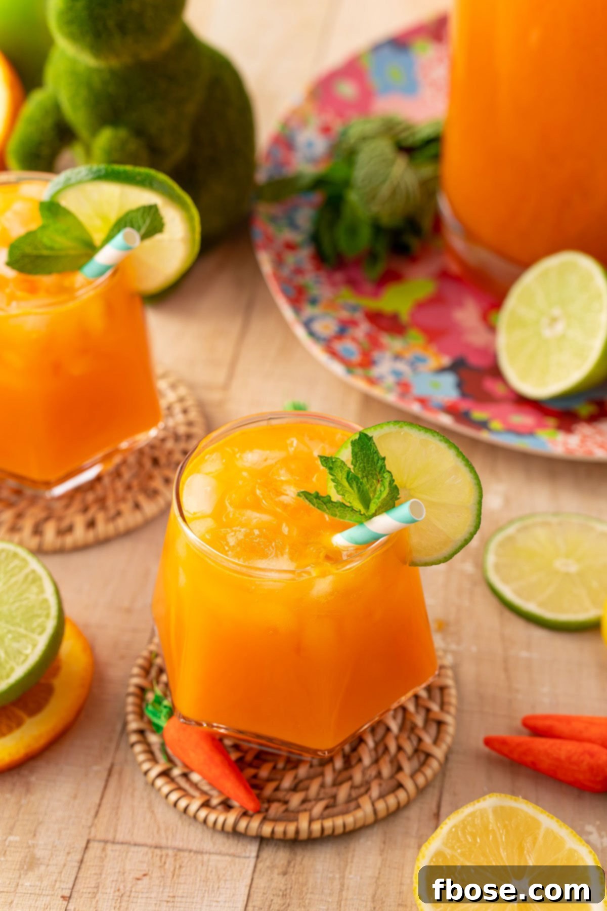 Two elegant glasses of homemade Easter punch, crafted with sweet orange and earthy carrot juice, sitting on a polished wooden table, ready to be enjoyed.