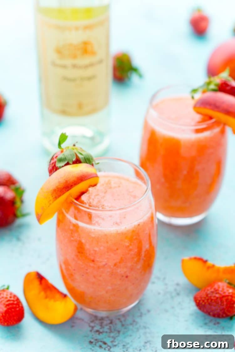 A person holding a Strawberry Peach Wine Slushie with a view of a summer setting.