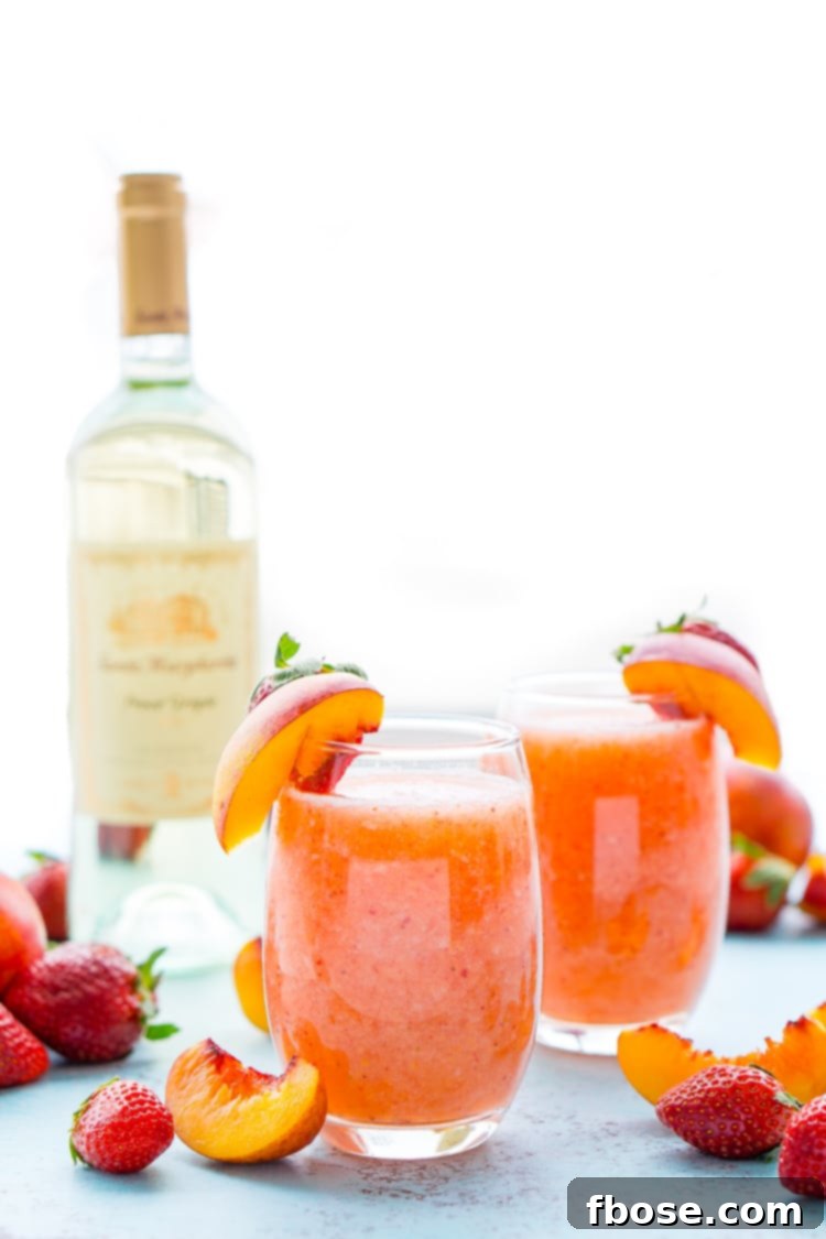 An overhead shot of a Strawberry Peach Wine Slushie, garnished with a peach slice and a strawberry.
