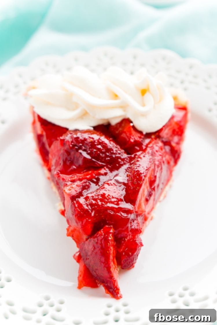 Pink Cloud Strawberry Pie 3 Close-up of a whole Strawberry Jello Pie, showcasing the fresh strawberries suspended in the glossy jello filling within a baked pie crust.
