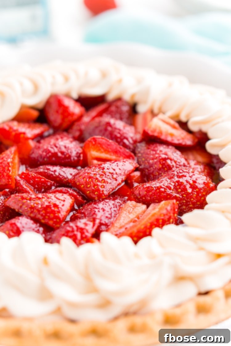 Pink Cloud Strawberry Pie 6 A beautiful Strawberry Jello Pie slice on a white plate, topped with fresh whipped cream and a whole strawberry.