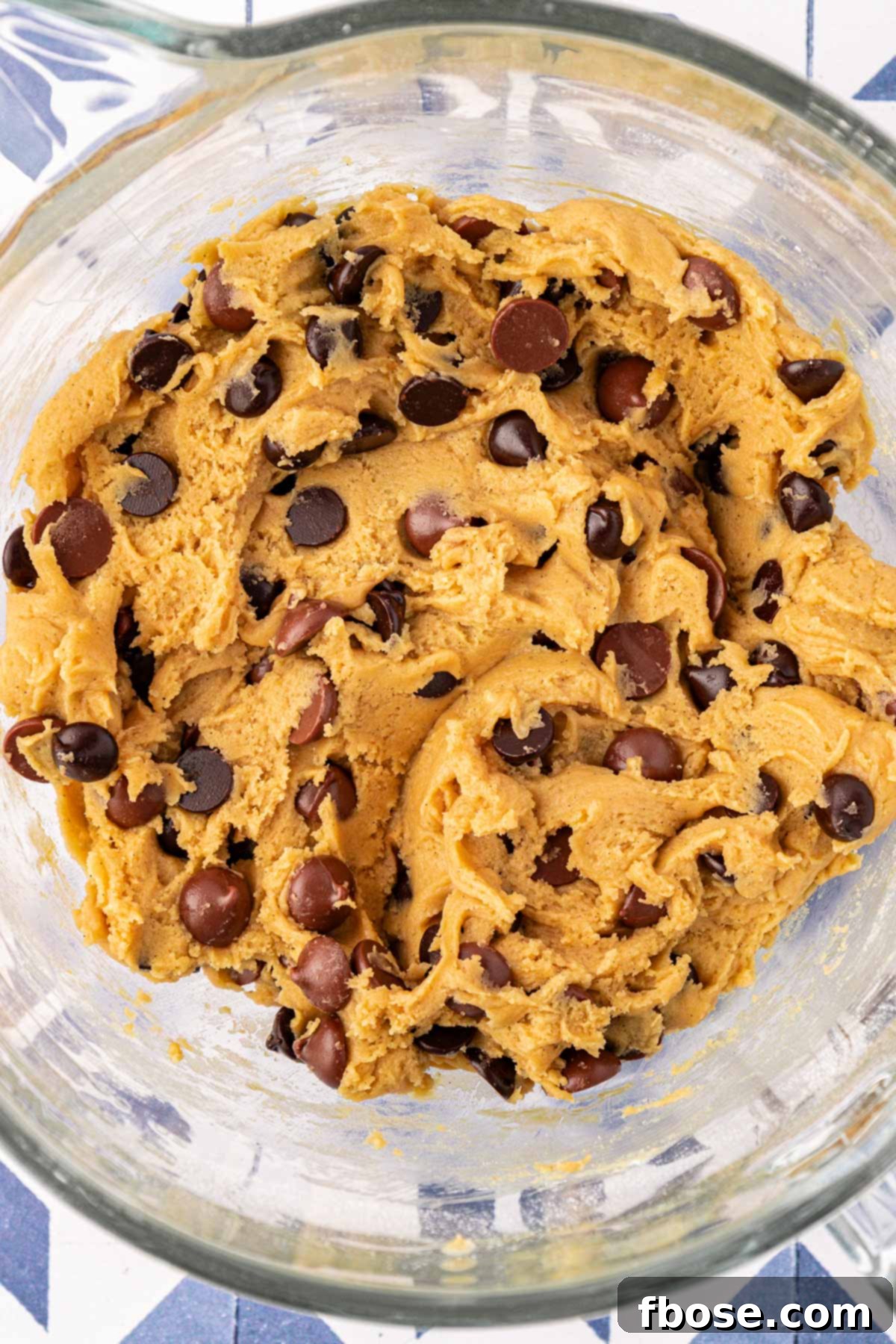 Chocolate chip cookie dough in a mixing bowl, ready for portioning.