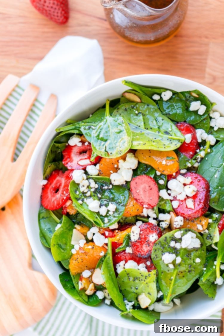 This Strawberry Spinach Salad will become your new go-to recipe for summer, it's made with simple, flavorful ingredients like goat cheese, almonds, poppyseeds, strawberries, mandarins, and spinach, and you can make it family or party-sized!