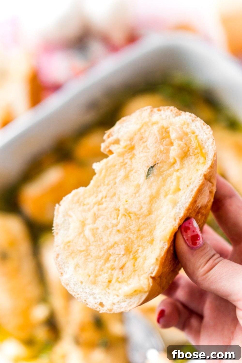Piece of bread with roasted garlic spread on it leftover from garlic chicken.