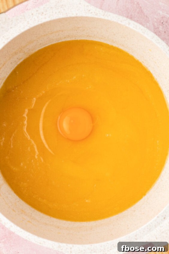 Egg being added to a butter and sugar base.