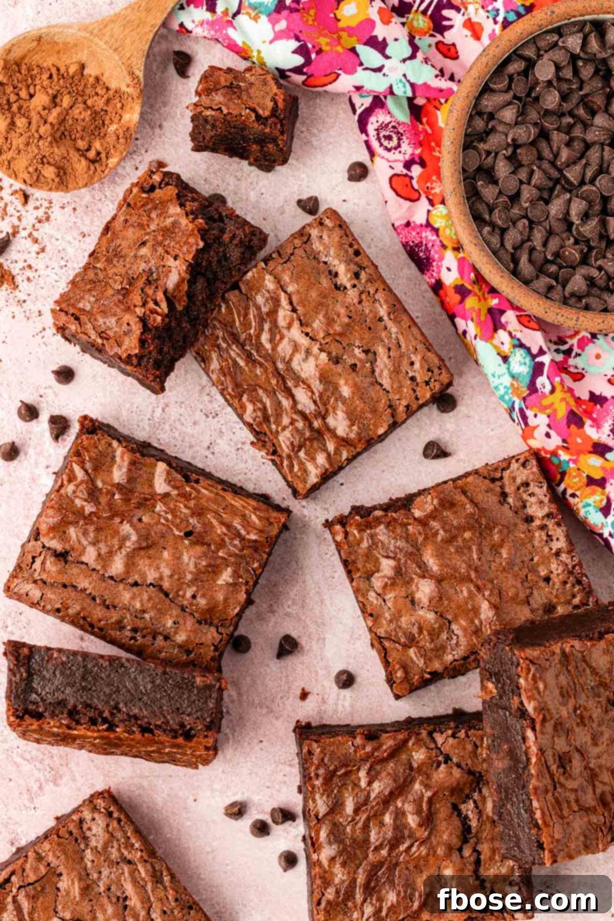 Brownie slices scattered on a table, highlighting the perfect square cuts and rich texture.
