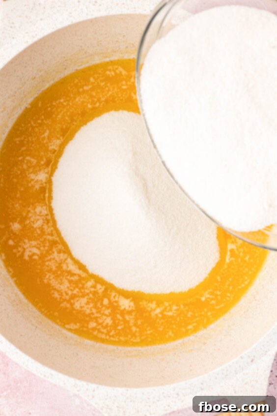 Sugar being added to melted butter in a pan.