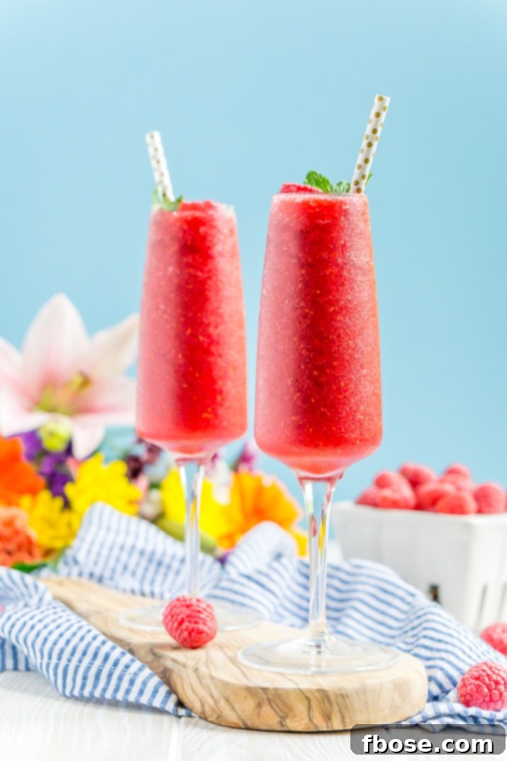 Raspberry Champagne Slushy Recipe 3 Close-up of a Raspberry Champagne Slushie, showing its icy texture and fresh raspberries.