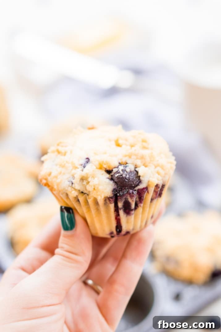 Overhead shot of freshly baked blueberry muffins with a delightful crumb topping, arranged appealingly.