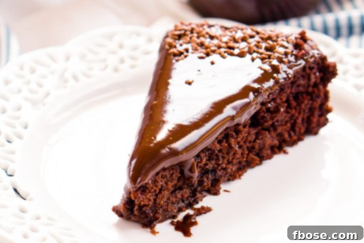 Slice of chocolate wacky cake on a white plate.