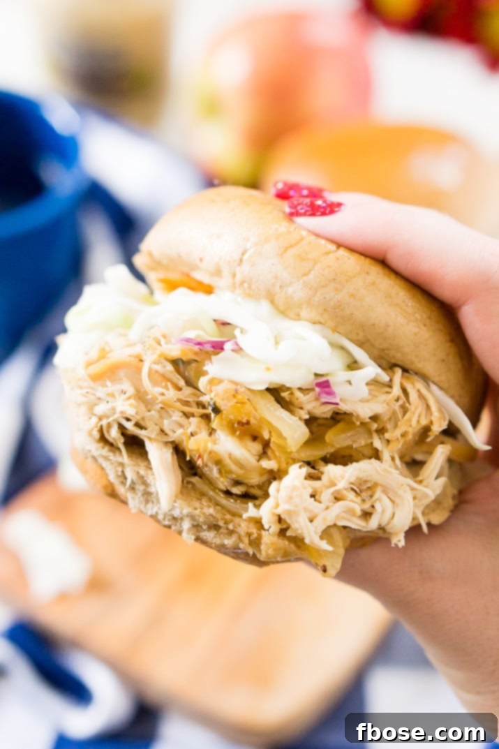 Close-up of a Weight Watchers Apple Cider Pulled Chicken sandwich with fresh vegetable slaw