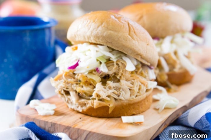 Shredded Apple Cider Pulled Chicken in a slow cooker, ready to serve