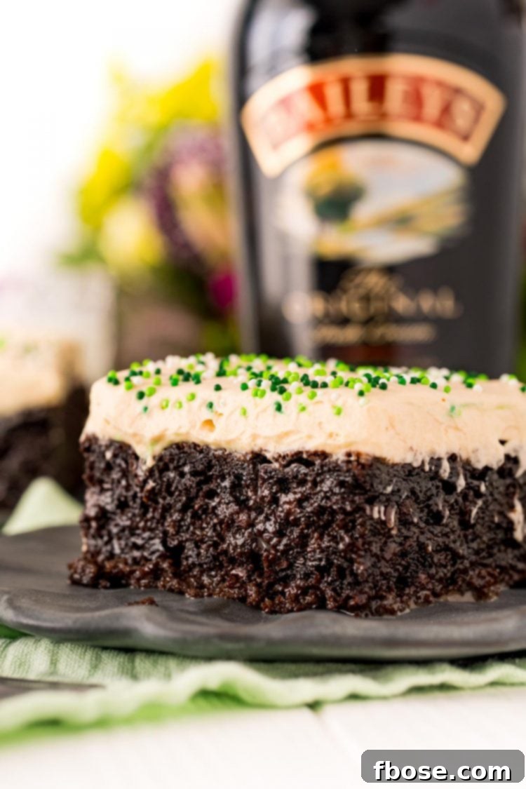 Close up photo of Irish cream cake on a gray plate, showcasing the rich chocolate and creamy frosting.