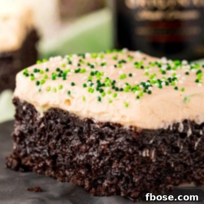 Close up photo of chocolate irish cream cake on a black plate, beautifully frosted.