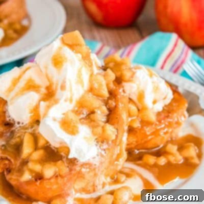 Apple french toast on a white plate topped with caramel and whipped cream.