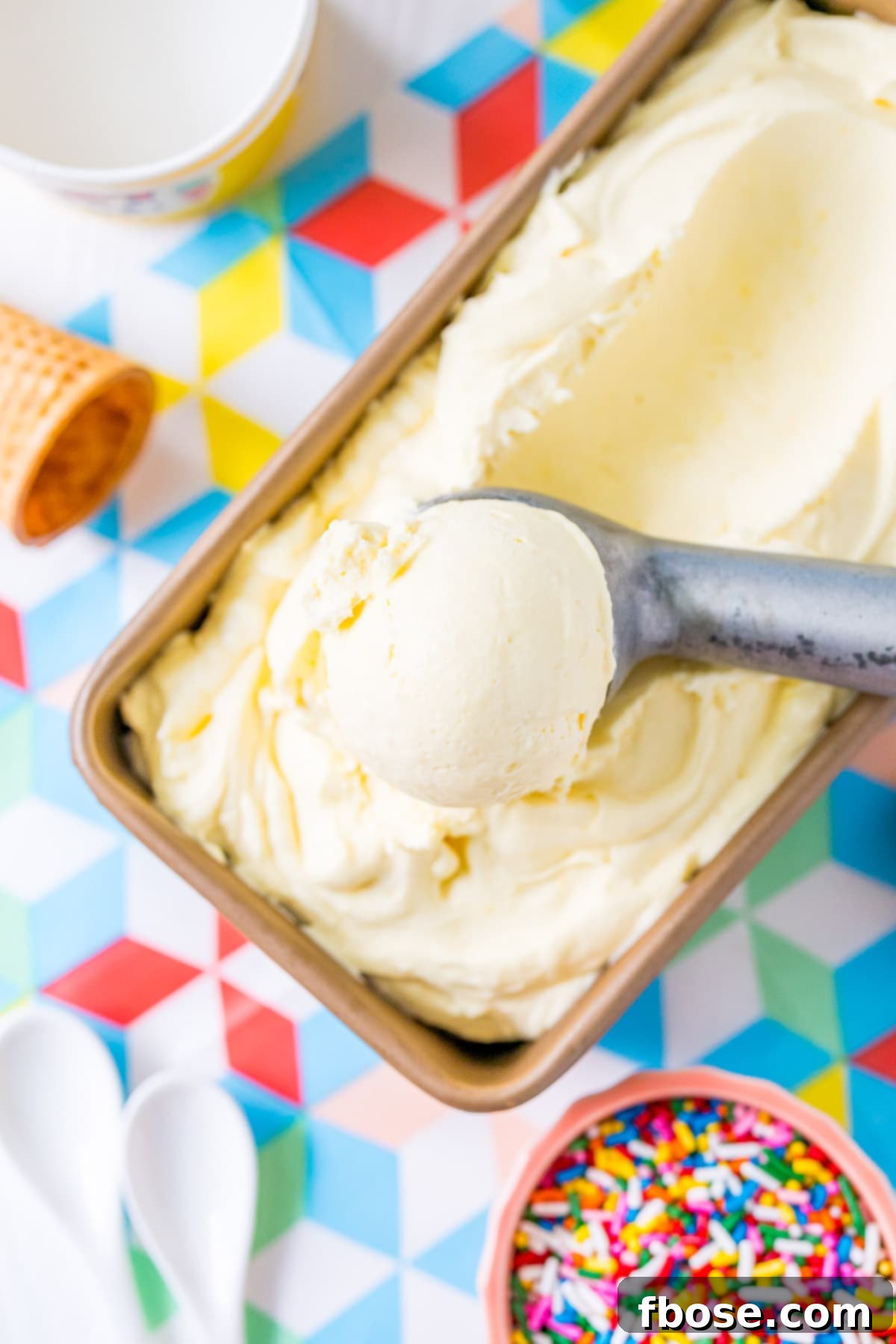 Ice cream scoop scooping vanilla ice cream.