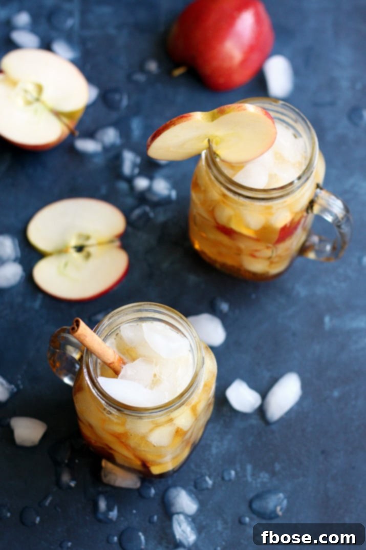 Apple Pimm's Cup garnished with apple slices and a cinnamon stick