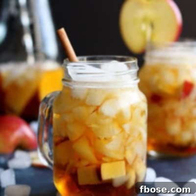 Apple Pimm's Cup cocktail with fresh apple slices and cinnamon