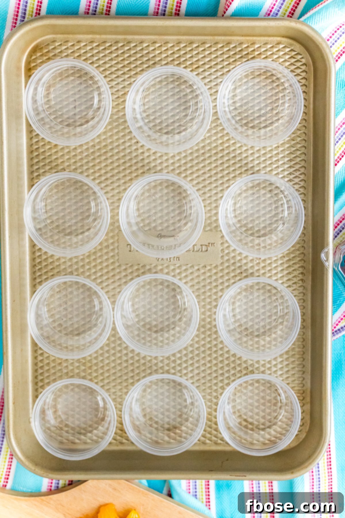 Condiment cups on a baking sheet ready to make jello shots.