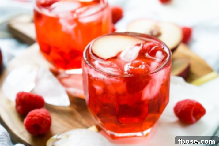 A close-up of a Red Russian Cocktail, showcasing its bright red hue and fresh cherry garnish
