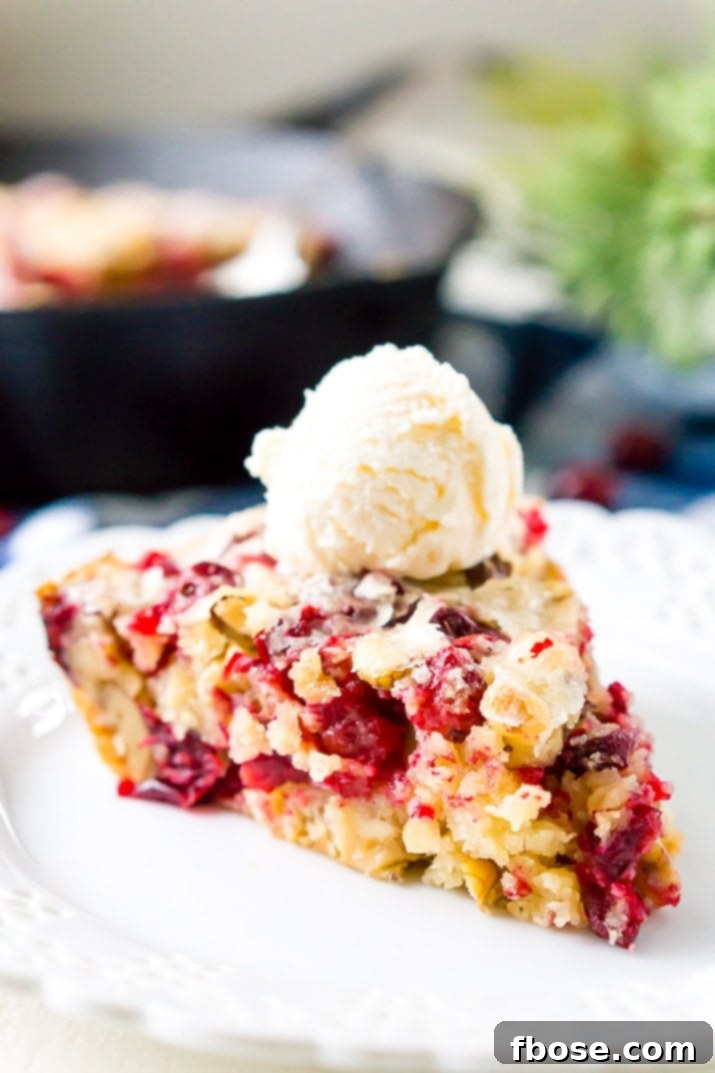 A festive Cranberry Skillet Cake, golden brown with vibrant red cranberries and a sprinkle of walnuts, perfect for holiday gatherings.